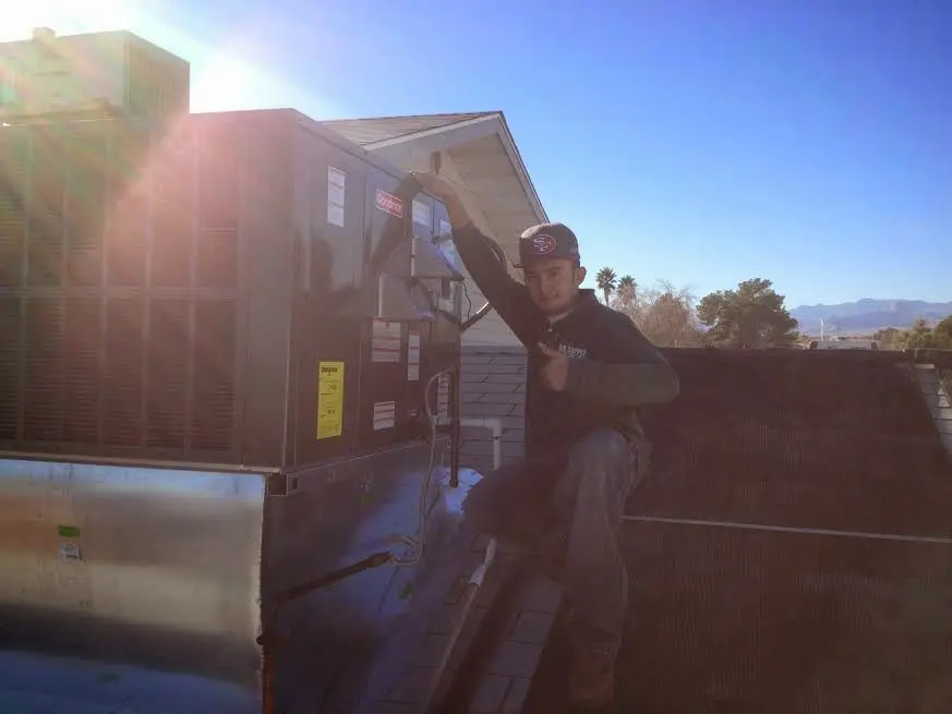 HVAC technician performing Heat Pump Repair on a rooftop unit in Jessup